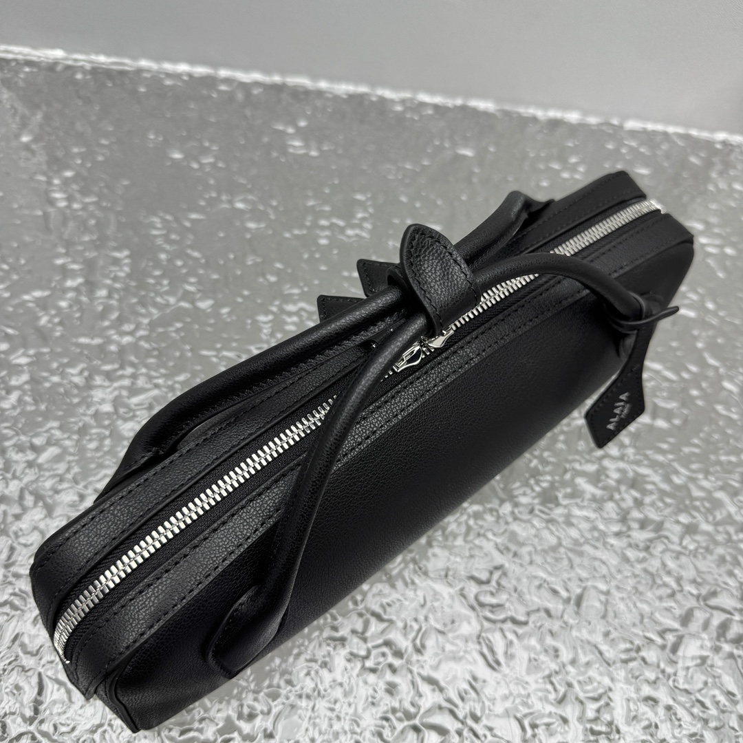 Black leather clutch bag Alaia LE TECKEL at the Park